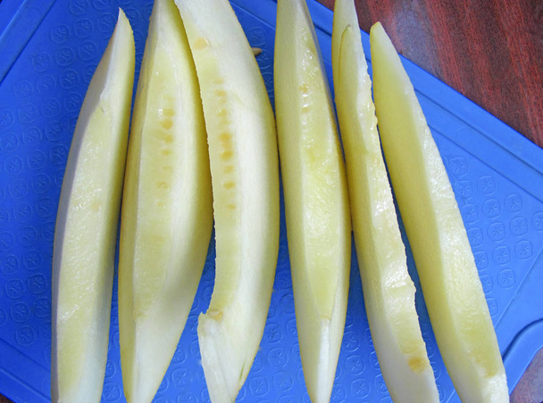 Ripe juicy melon slices on the blue background. - Photo, Image