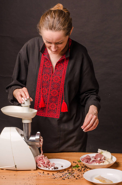 Nainen käyttää hiomakonetta jauhelihan valmistukseen keittiössä - Valokuva, kuva