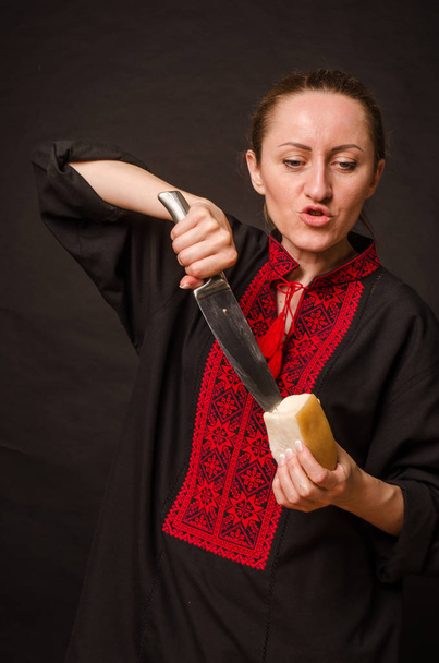 Een vrouw snijdt gerookt vlees in de keuken. - Foto, afbeelding