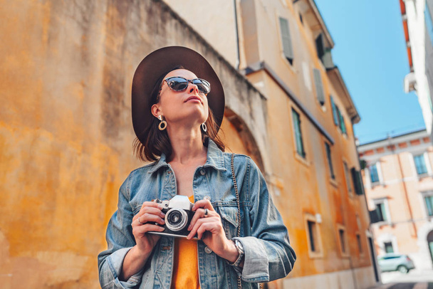 Attractive photographer with a retro camera outdoors - Photo, Image