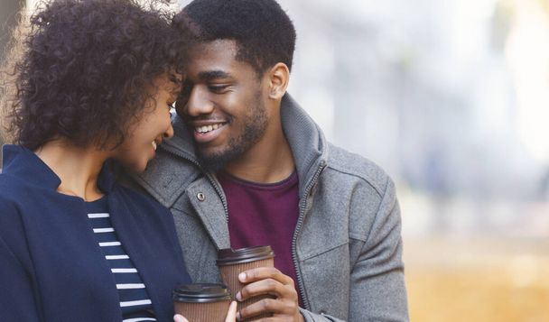 Afro homme et femme se réchauffent avec du café dans le parc
 - Photo, image