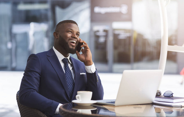 Ευτυχισμένος επιχειρηματίας μιλώντας στο τηλέφωνο εργασίας σε υπαίθριο καφέ - Φωτογραφία, εικόνα