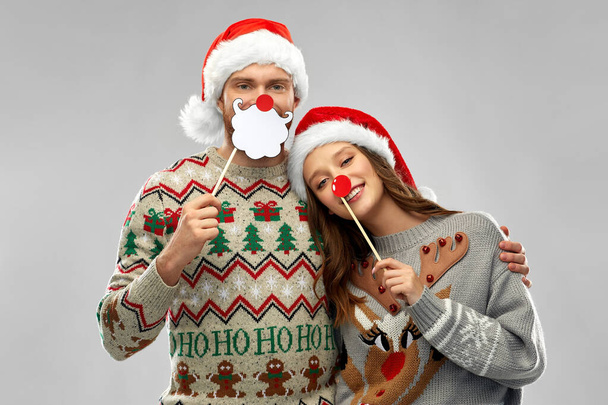 couple with christmas party props in ugly sweaters - Фото, изображение