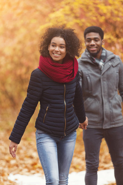 Podzimní procházka. Šťastný muž sleduje přítelkyni, procházka v parku - Fotografie, Obrázek