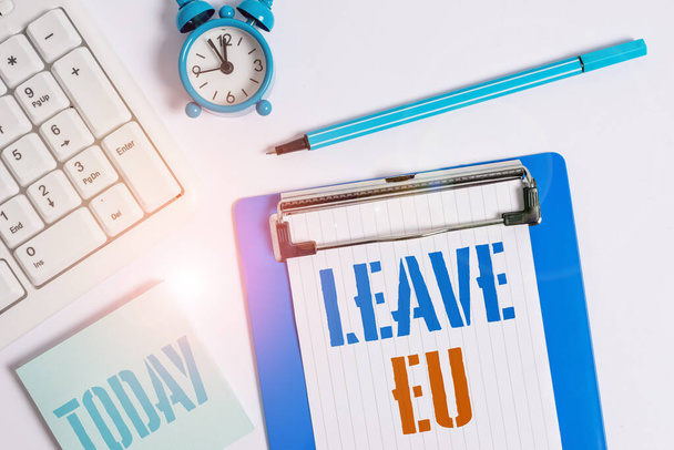 Writing note showing Leave Eu. Business photo showcasing An act of a demonstrating to leave a country that belongs to Europe Flat lay above table with clock pc keyboard and copy space note paper. - Photo, Image