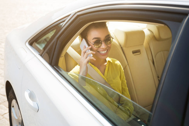 Χαρούμενη Αφρο γυναίκα μιλάει στο τηλέφωνο στο αυτοκίνητο - Φωτογραφία, εικόνα