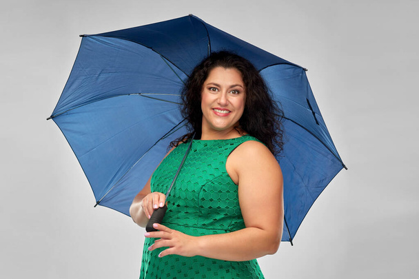 happy woman in green dress with blue umbrella - Foto, imagen