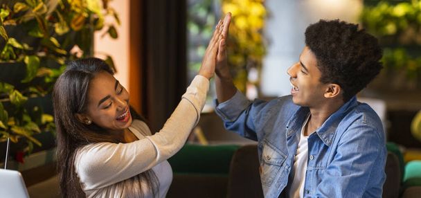 Vrolijke jongen en meisje geven elkaar high five - Foto, afbeelding