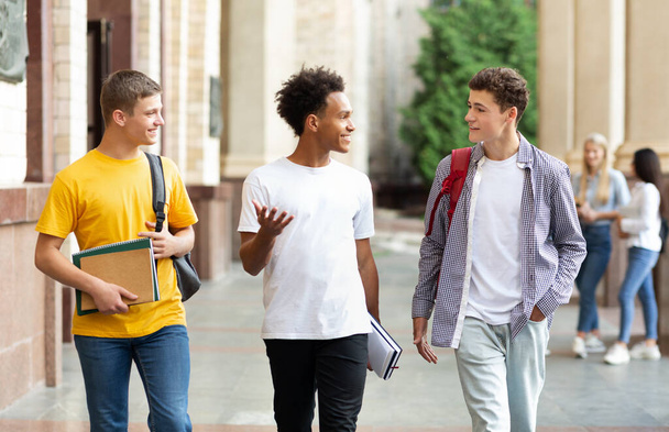 University life. Guys walking in campus and chatting - Foto, Bild