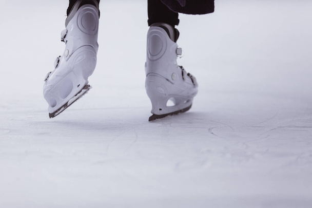close-up de pernas de mulheres em patins no inverno em uma pista de patinação aberta, lugar de texto
 - Foto, Imagem