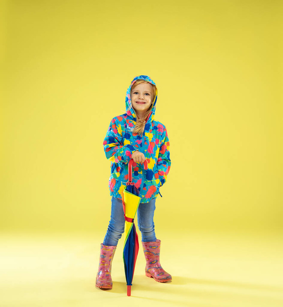 A full length portrait of a bright fashionable girl in a raincoat - Photo, Image