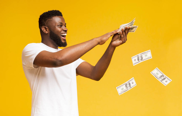 Mutlu afrikalı Amerikalı adam para banknotlar dışarı atma - Fotoğraf, Görsel