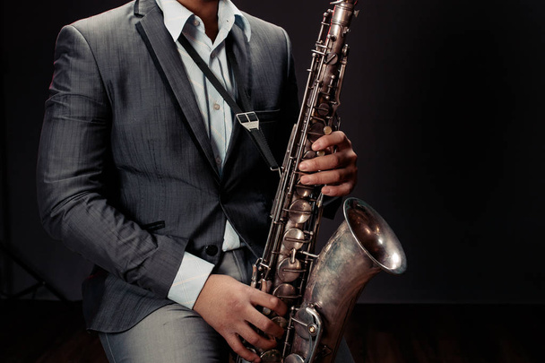 El joven toca el saxofón. De cerca.
 - Foto, Imagen