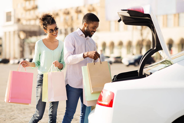 Young couple putting shopping bags in car - Photo, Image