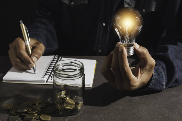 Main d'un homme tenant une ampoule et espace de copie pour la comptabilité
, - Photo, image