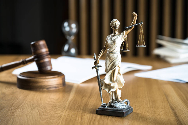 Δίκαιο και Δικαιοσύνη, Άγαλμα της τυφλής θεάς Θέμη σε ξύλινο τραπέζι με θολή φόντο. - Φωτογραφία, εικόνα