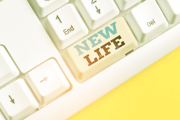 Rukopis New Life. Koncept znamená začátek změny v existenci jednotlivce nebo zvířete Bílá PC klávesnice s prázdným poznámkovým papírem nad bílým pozadím klávesy copy space. - Fotografie, Obrázek