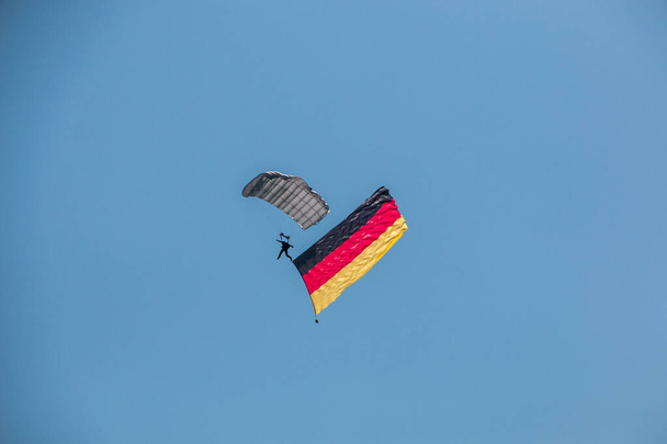 Німецький скайдайвер в повітрі з німецьким прапором. - Фото, зображення