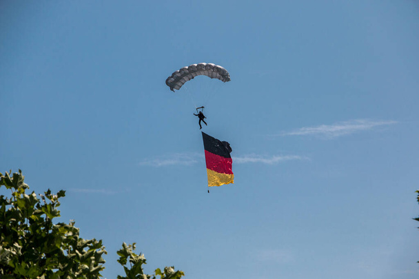 Alman paraşütçüsü Alman bayrağıyla havada. - Fotoğraf, Görsel