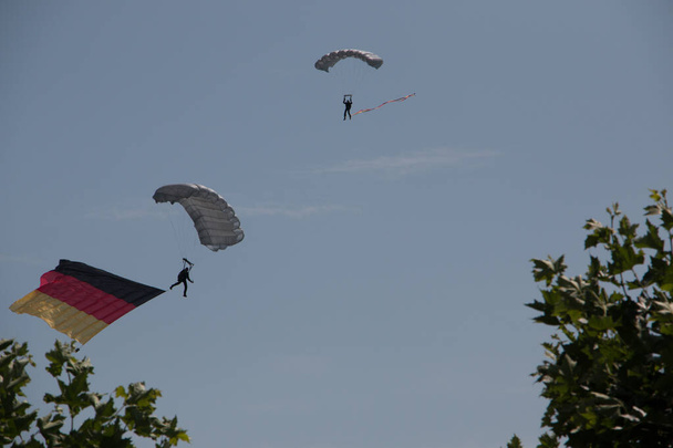 Німецький скайдайвер в повітрі з німецьким прапором. - Фото, зображення