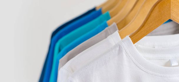 Κοντινό πλάνο του Πολύχρωμα t-shirts σε κρεμάστρες, φόντο ένδυσης - Φωτογραφία, εικόνα