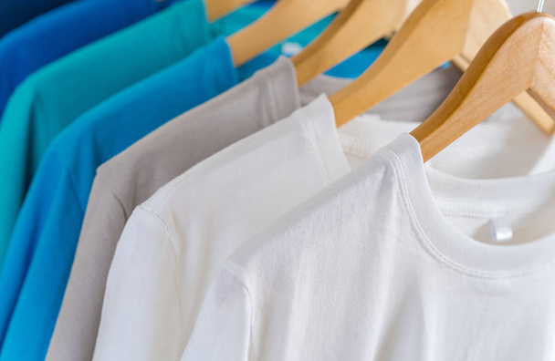 Close-up van Kleurrijke t-shirts op hangers, kleding achtergrond - Foto, afbeelding