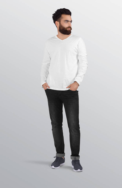 Standing male model wearing plain white v neck long sleeve shirt in black denim jeans pant. Isolated background - Fotografie, Obrázek