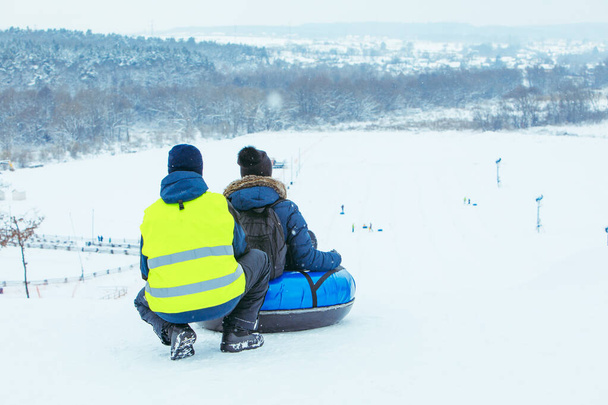 Χειμερινές δραστηριότητες διασκέδασης. βόλτα κάτω από το λόφο με σωλήνα χιονιού - Φωτογραφία, εικόνα