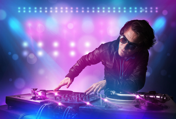 Disc jockey mixando musica sui giradischi sul palco con luci e
 - Foto, immagini