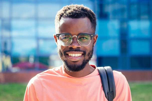 portrait stylish and handsome African student American man in glasses smiling toothy professor on the street - Фото, изображение