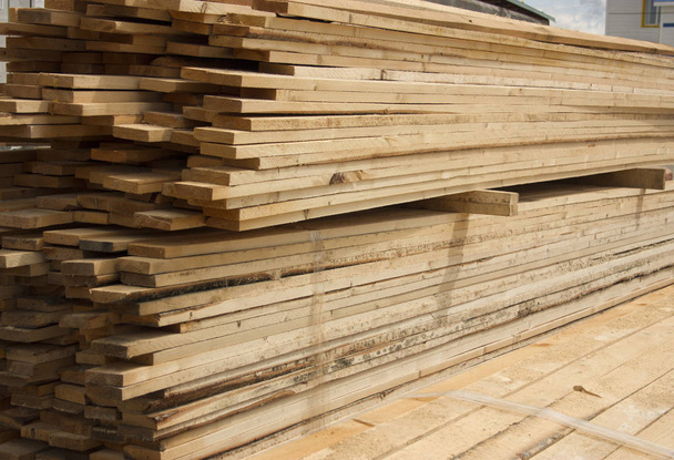 Almacén de madera. Tablones de madera largos apilados al aire libre
 - Foto, Imagen
