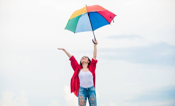 Rainy weather. Good mood. Good vibes. Open minded person. Girl feeling good sky background. Easy and free. Good weather. Welcoming fall. Pretty woman with colorful umbrella. Rainbow umbrella - Foto, imagen
