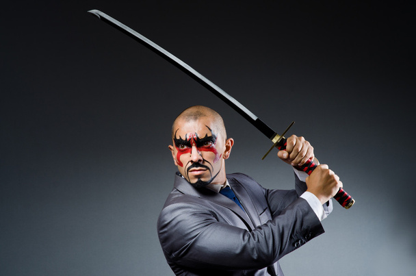 Hombre con pintura facial y espada
 - Foto, imagen