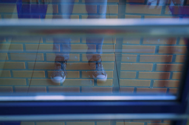 réflexion abstraite des jambes sur un fond de mur de briques
 - Photo, image