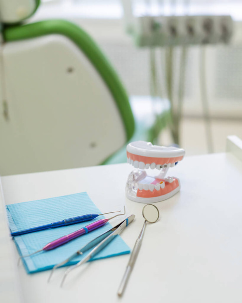 Sterile instruments are in the dentists office. A mirror, tweezers, a probe and a jaw layout are on the orthodontists table. Oral hygiene, caries prevention, examination. - Photo, Image