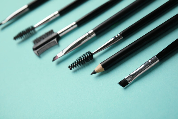 Set of professional eyebrow tools on turquoise background - Фото, зображення