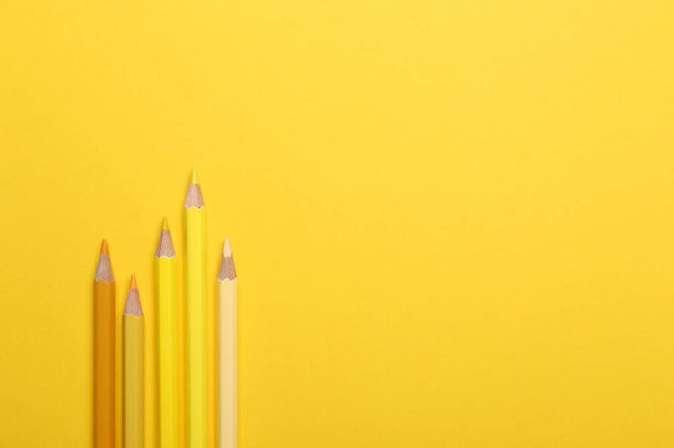 Цветные карандаши на желтом фоне, плоский узор. Пространство для текста
 - Фото, изображение