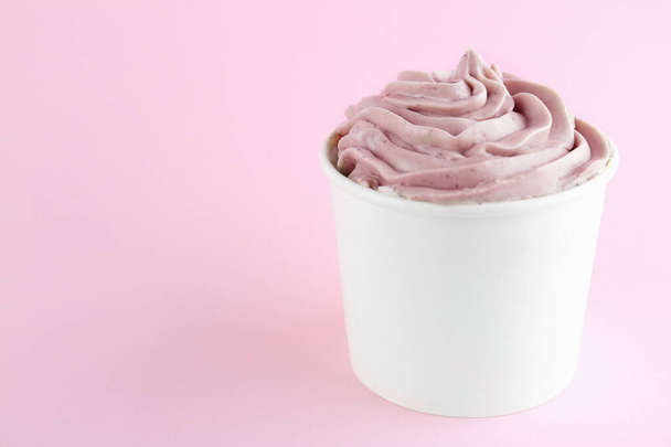 Cup with tasty frozen yogurt on pink background. Space for text - Φωτογραφία, εικόνα