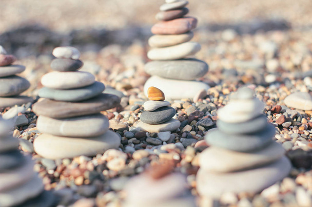 Zen pyramid of spa stones on the blurred sea background. Sand on a beach. Sea shores. Place for text. - Foto, Imagen