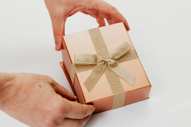 Hands open box with ribbon bow on white background - Foto, Bild