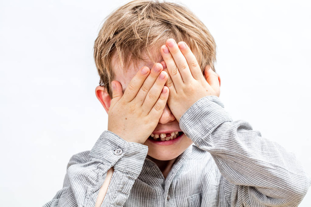 joyful smiling child hiding his face playing hide and seek - Photo, image