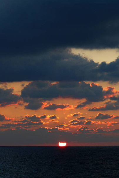Słońce zachodzi nad horyzontem Morza Śródziemnego w północnym Izraelu i dzień się kończy.  - Zdjęcie, obraz