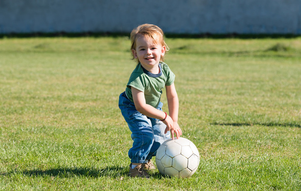 маленький хлопчик грає з м'ячем
 - Фото, зображення