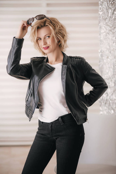 young woman in leather jacket in studio - Fotó, kép