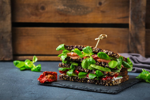 Свежий сэндвич с ржаным хлебом с ветчиной, салатом и помидорами
 - Фото, изображение