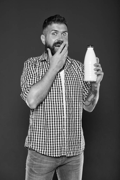 Lactose diet. Health care and diet. Milk products. Consuming lactose. Healthy nutrition. Yogurt probiotics and prebiotics. Bearded man hold white bottle with milk. Brutal caucasian hipster drink milk - Фото, изображение