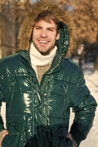 Man. It is cold outside. Forest in snow. Fresh air. Vacation and traveling. Happy man on winter holidays. Snowy weather. Trendy winter coat. Winter fashion. Warm clothes. Shopping in any weather - Foto, Imagen