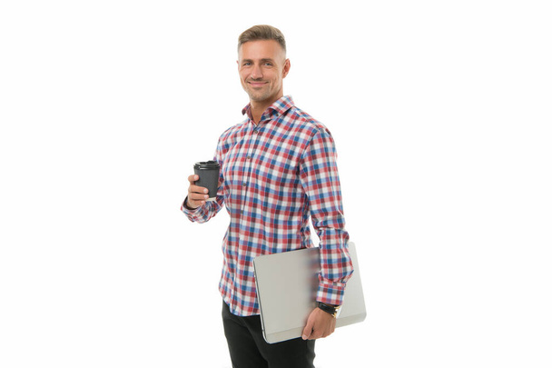 Fuel for my brain. Handsome smiling man enjoying his coffee to go. Happy hipster holding laptop and coffee cup white background. Coffee wakes me up in morning. Regular office worker concept - Valokuva, kuva