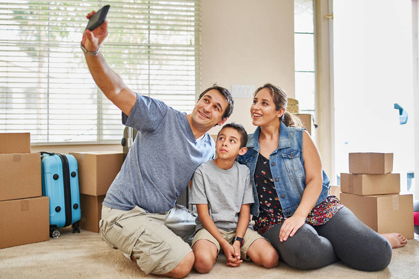 счастливая латиноамериканская семья делает селфи после переезда в новый дом
 - Фото, изображение