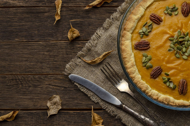 домашній гарбузовий пиріг, гарбузове насіння та осіннє листя на дерев'яному фоні
 - Фото, зображення